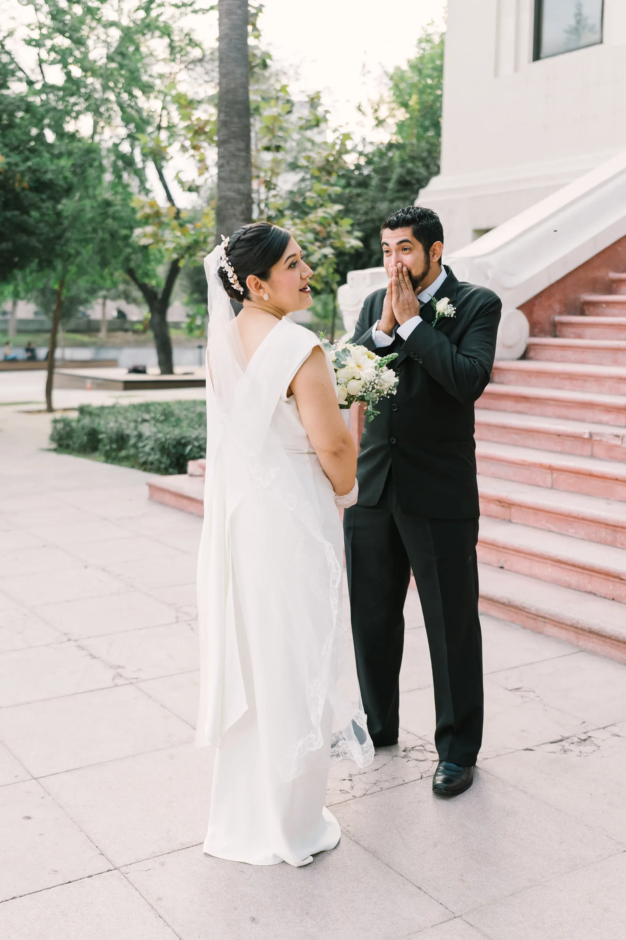 Novio emocionado cubriéndose la boca al ver a la novia por primera vez en first look