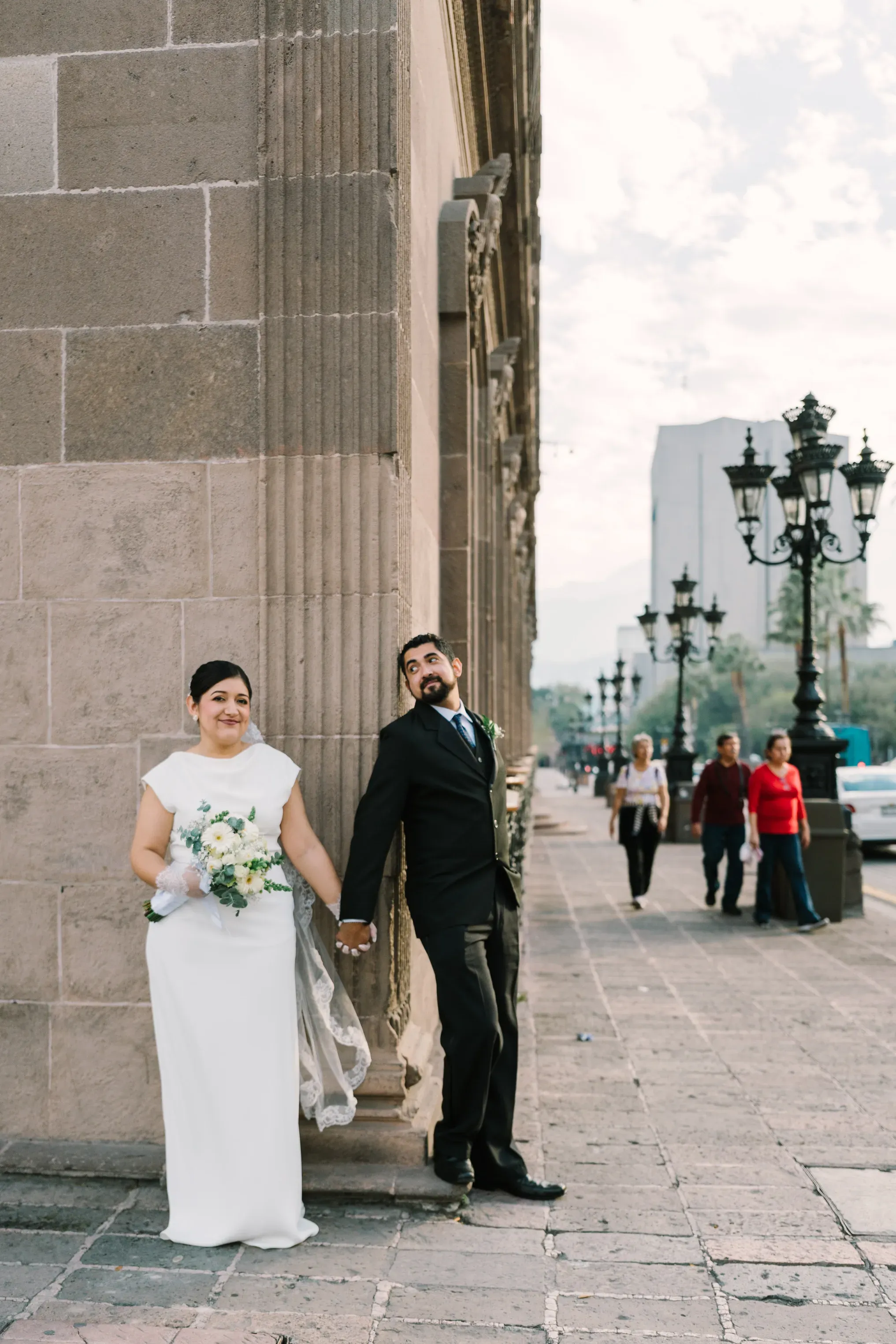 Amy y Jorge posando junto a columna de piedra en calle histórica del centro de Monterrey